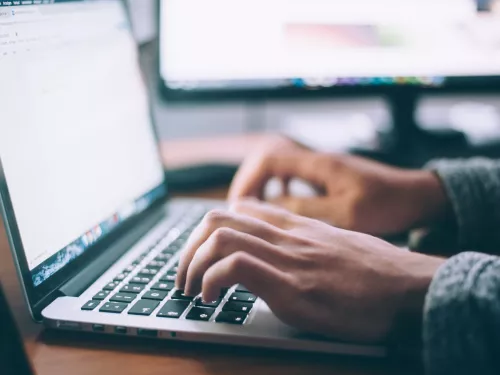 man working on a computer writing a cv