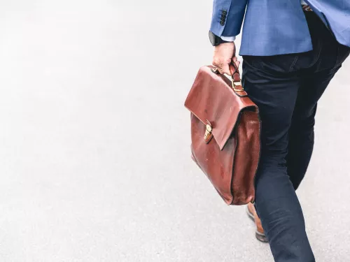 man holding a bag walking in the street